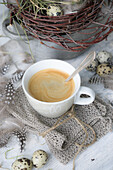 A cup of coffee on a knitted napkin on the Easter table