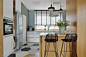 Modern kitchen with counter and bar stools, hexagonal tiled floor
