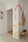 Coat hooks and shoe bench in the hallway with hand painting