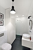 Badezimmer mit weißen Wandfliesen und Duschbereich