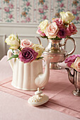 Pastellfarbene Rosen in Teekannen