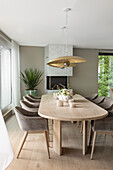 Long dining table in light wood with elegant upholstered shell chairs