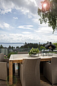 Holztisch mit eleganten Stühlen auf der Terrasse mit Blick auf den Fjord