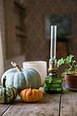 Small oil lamp and gourds on wooden table