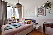 Double bed in the bedroom with pastel pink accents