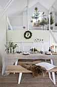 Weihnachtlich gedeckter Esstisch mit vielen Kerzen und Tannenbaum-Dekoration