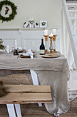Set dining table with linen tablecloth and candles, Christmas decorations