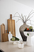 Decorative bowls, chopping boards and antique vase on kitchen island