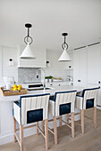 Bright kitchen, bar stools with blue and white upholstery at kitchen island