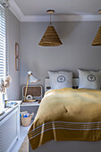 Double bed in the guest room with light grey walls