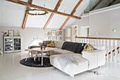 Bright living room with upholstered furniture in the attic with exposed wooden beams