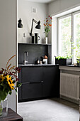 Open-plan kitchen, cupboard and back wall in black