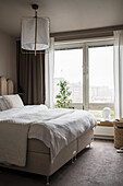 Double bed in beige-toned bedroom