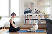Woman with cat on yoga mat
