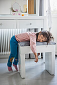 Tired girl sleeping on stool