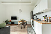 White kitchenette with wooden worktop and small dining area in the living room