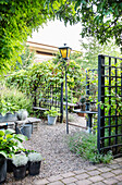 Graveled area surrounded by airy trellises as garden room dividers