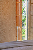Movable wooden slats as privacy screen in the bedroom