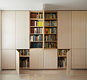 Custom built in wall storage unit with bookshelf in light wood