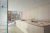 Minimalist kitchen with glass staircase and access to the courtyard
