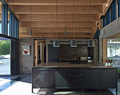 Kitchen island in open kitchen with wooden ceiling in an architect's house