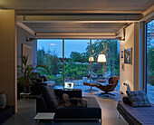 Living room with couch and chairs and garden view at dusk