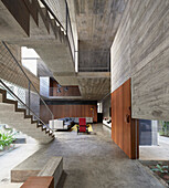 Open living plan with view of stairs and two levels in a concrete house