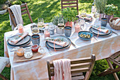 Gedeckter Tisch mit Keramikgeschirr und selbst gefärbter Tischwäsche