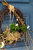 Wreath with wood anemone (Anemone nemorosa) and palm catkins by the door