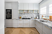 Modern grey kitchen with stone worktop and fluted cabinet fronts