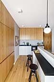 Open kitchen in grey tones combined with light walnut wood