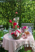 Gartentisch mit Frühlingsblumen und Gugelhupf