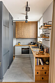 Kitchen in muted grey tones and natural wood, large format floor tiles in concrete look