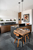 Open kitchen in dark brown tones Small, folding dining table at the counter
