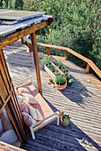 View from above of wooden terrace with day bed