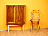 Vintage-look cupboard, classic chair next to it