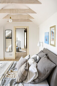 White attic bedroom with double bed and pillows in natural fabrics