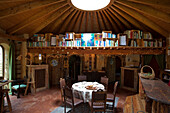 Round dining table and gallery bookcase in rustic ambience