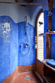 Duschbereich mit blauen Wänden und Spiegelmosaik