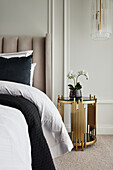 Detail of opulent bedroom in neutral tones with paneled walls and pendant lighting