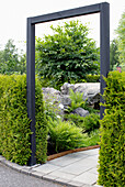 Black wooden frame as an eye-catcher with ferns and stone elements