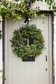 Weihnachtlicher Türkranz mit Tannenzweigen an einer Haustür