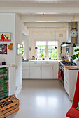 Kitchen with white cupboards and windows with a view of the greenery