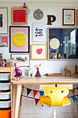 Children's desk with yellow chair and colorful wall decoration