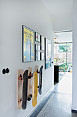 Wall with skateboards and framed pictures in modern hallway