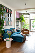 Living room with blue velvet sofa and assorted houseplants