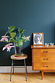 Flowering plant on a stool with vintage furniture and decorations in a stylish living area