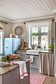 Country kitchen with light blue retro fridge and wooden elements
