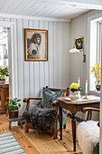 Gemütliche Leseecke mit Vintage-Sessel und Frühlingsblumen auf Holztisch