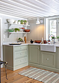 Country kitchen with green cupboards and white shelves